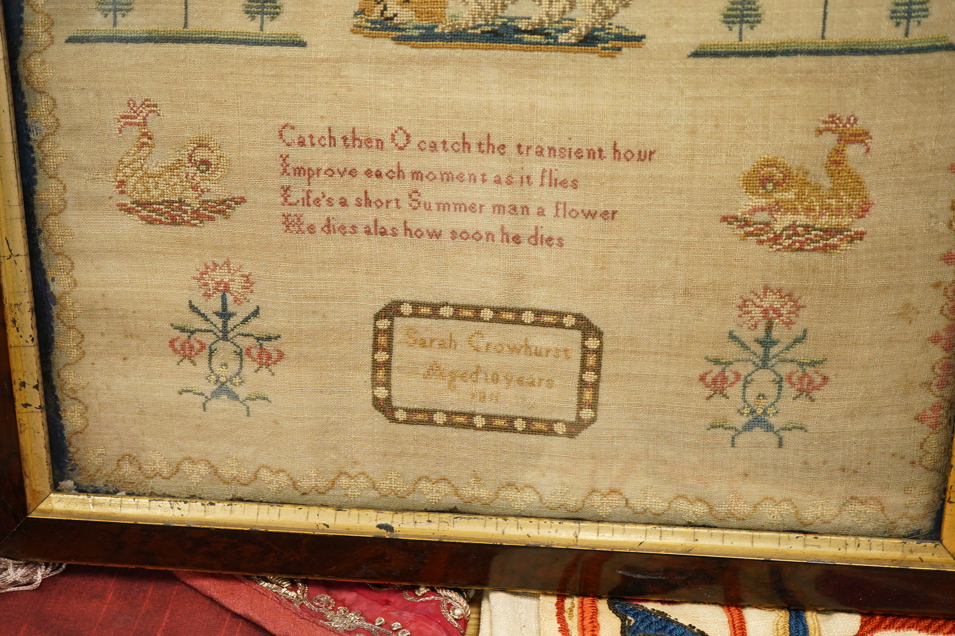 An early 19th century framed sampler by Sarah Crowhurst aged 10 years, dated 1811. Very finely embroidered, on fine linen, with a line of alphabet, then a religious verse and a large central spaniel motif between stylist